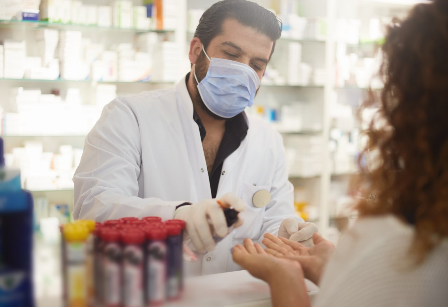 Pharmacists in a pharmacy wearing masks
