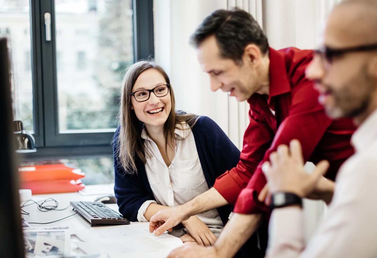 Group of adults near a computer smiling